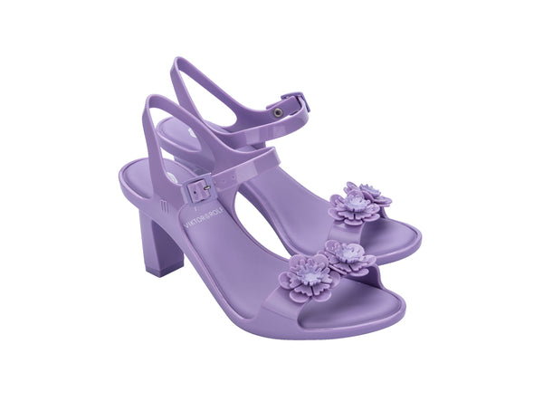 Melissa Lady Emme Blossom Viktor & Rolf Floral Lilac Heel Sandal for Women – Elegant high-heeled sandal with floral embellishments, offering a stylish and feminine touch for special occasions.